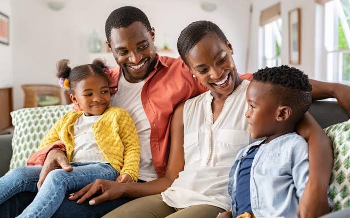 Happy family smiling together in their JNESIS living room
